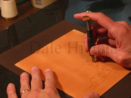 Carving the pattern with a swivel knife.